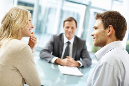 Couple smiling at each other with an adviser sitting across from them